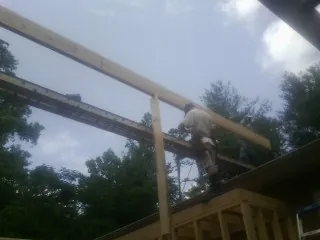 Carpenter setting a ridge beam over a new addition frame — Ice Dam Removal by Roofing Brothers in Fleetwood