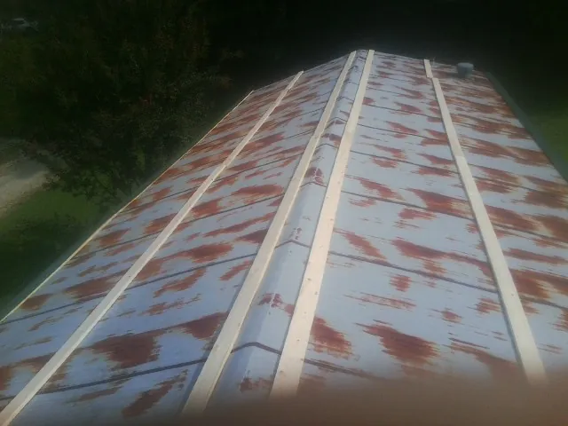 Rusted metal roof panels with new wood purlins before replacement — Storm Damage Roof Repair in Fleetwood by Roofing Brothers